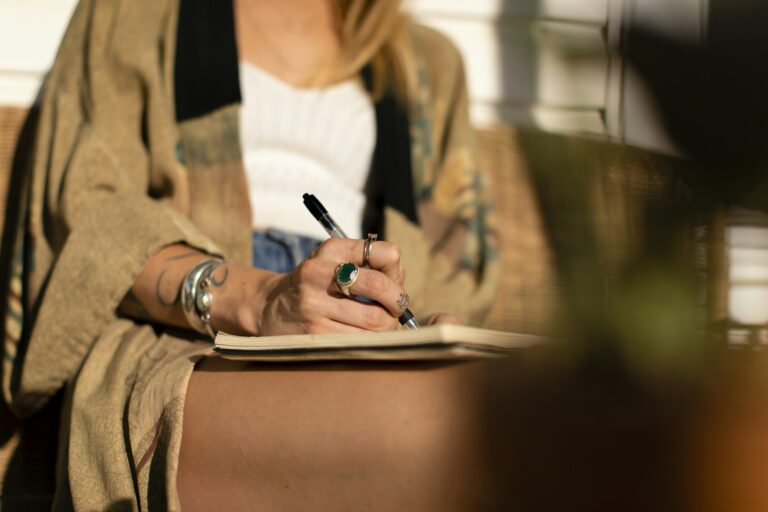 Relaxed woman writing in Notebook. Young girl taking notes in Journal. Journaling. Journaling bei Trennungsschmerz.