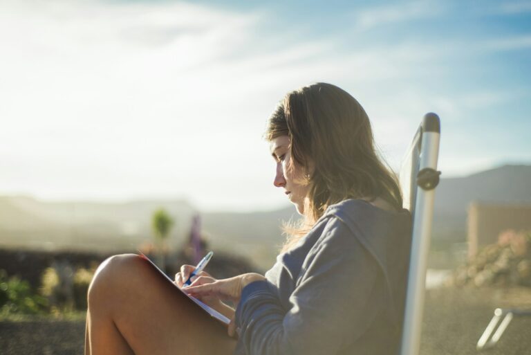 Woman on deckchair writing in journal, Corralejo, Fuerteventura, Canary Islands